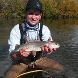 Headshot of young adult male in river holding a fish and ID Life staff member Joseph V.