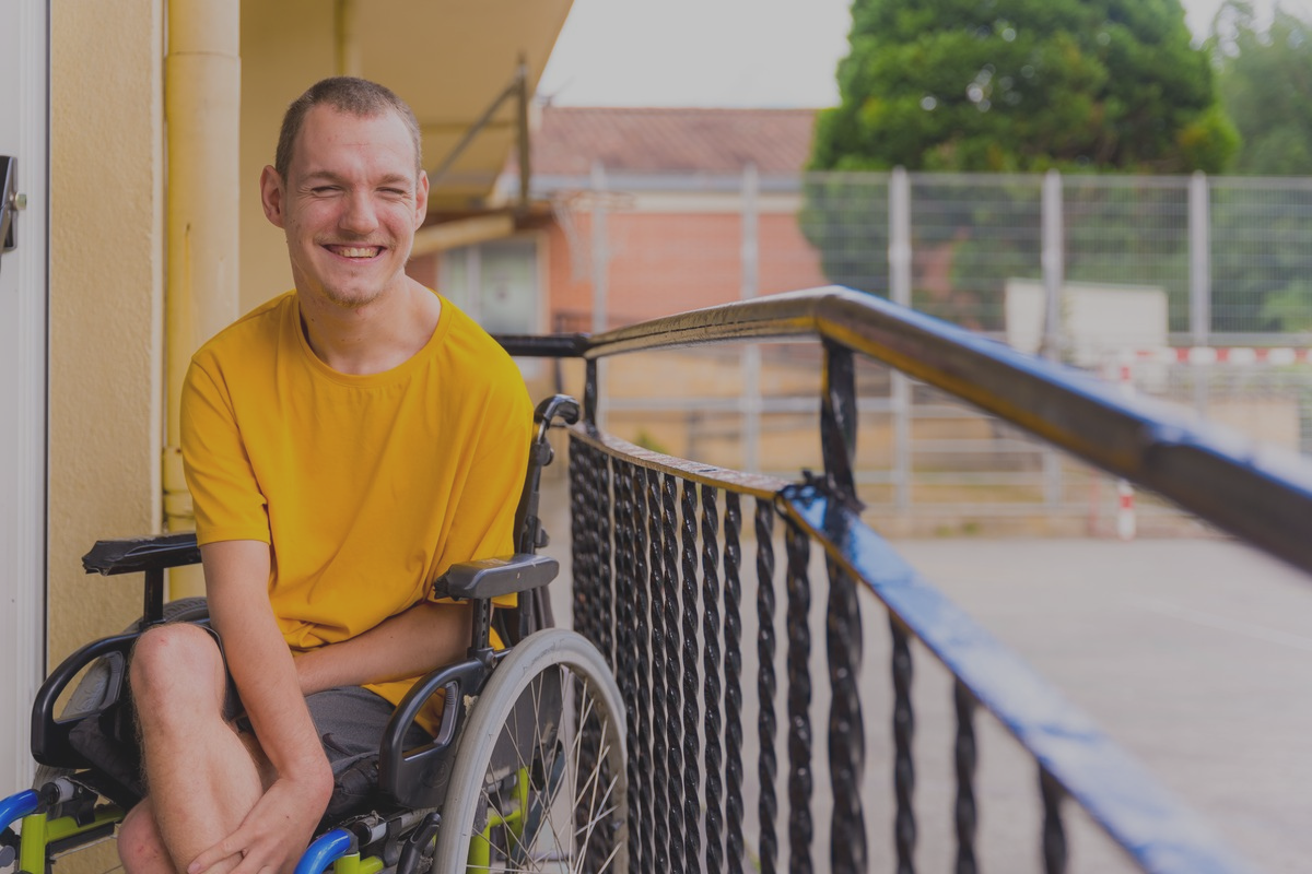 Disabled Person Dressed In Yellow In A Wheelchair
