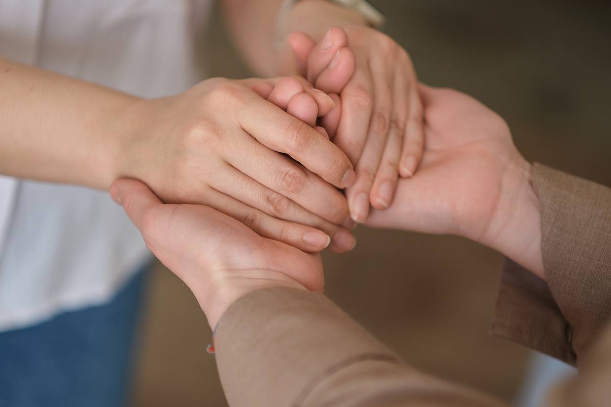 Woman Holding Another pair of hands In A Comforting Embrace