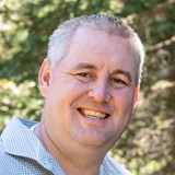 Headshot of middle aged adult with gray hair and ID Life staff member Michael L.