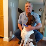Headshot of elderly board member Mark G. in front of his dog